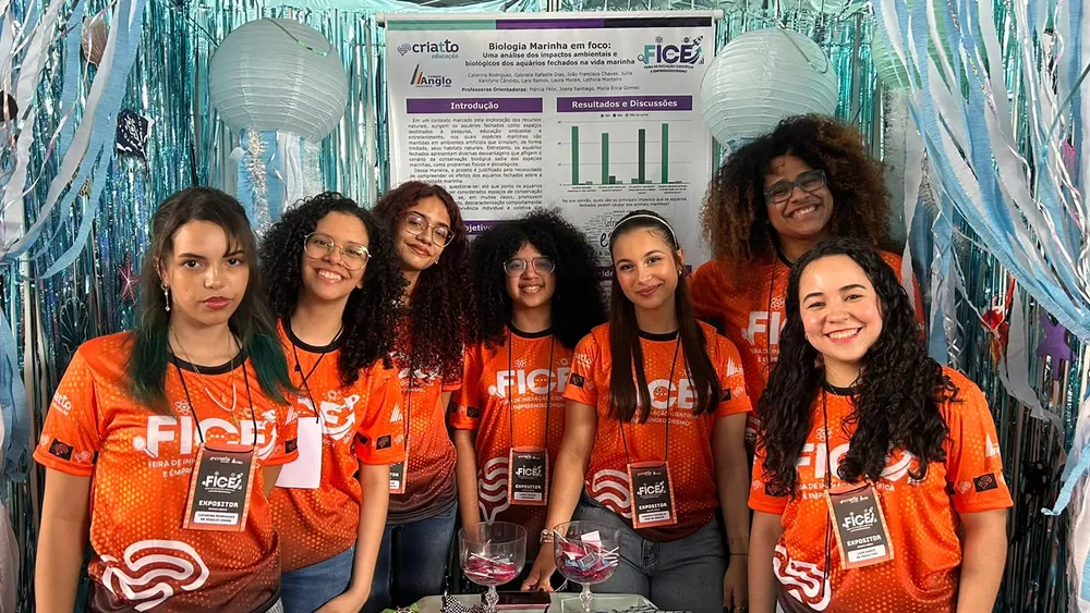 Estudantes apresentando seu trabalho em um estande da FICE